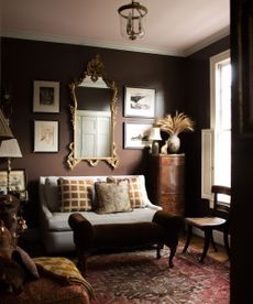 dark living room with brown walls, eclectic decor, red vintage rug