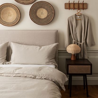 bedroom with cream colour wall cream colour bed with cushion and wall pieces