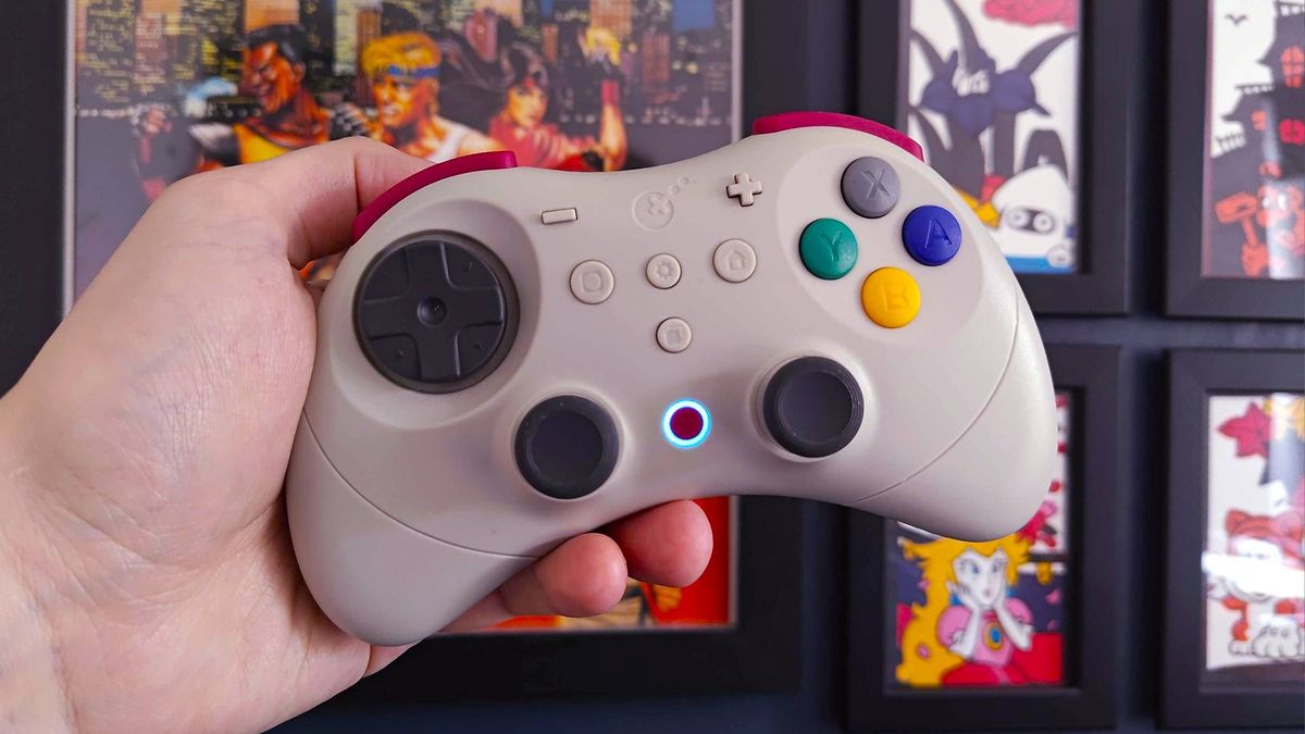 Hand holding Gulikit Elves 2 Pro controller with middle power light on.