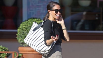 Meghan Markle in a sweater, shorts, ballet flats, and British poppy pin.