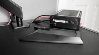 The Minisforum AtomMan G7 PT on its side on a desk showing where its power cable connects