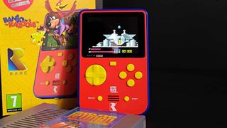 Super Pocket leaning against box with Banjo-Kazooie leaping out of handheld on front and a copy of Solar Jetman for NES sitting in front.