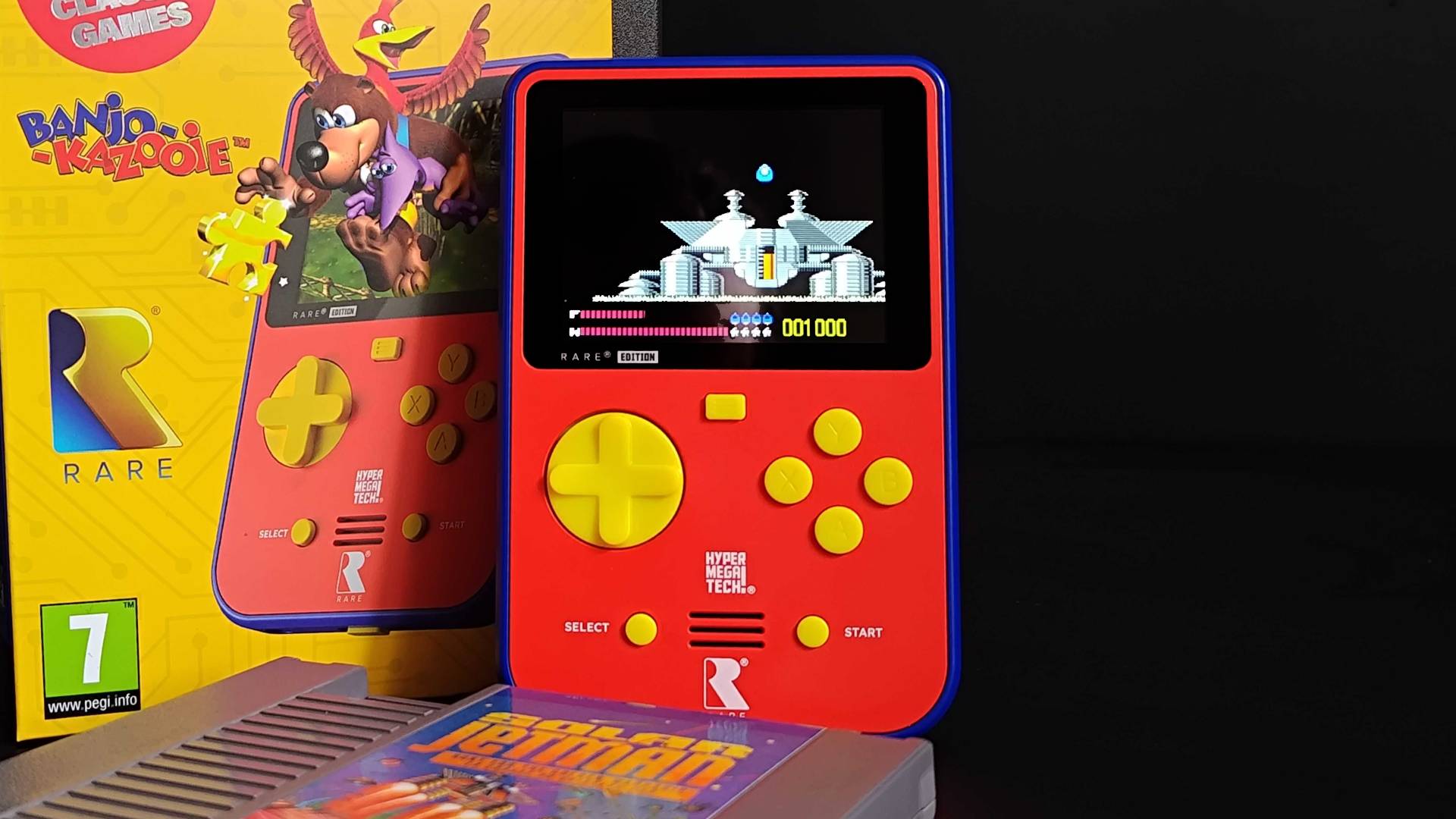 Super Pocket leaning against box with Banjo-Kazooie leaping out of handheld on front and a copy of Solar Jetman for NES sitting in front.