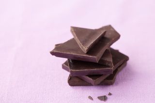 pieces of dark chocolate on pink background