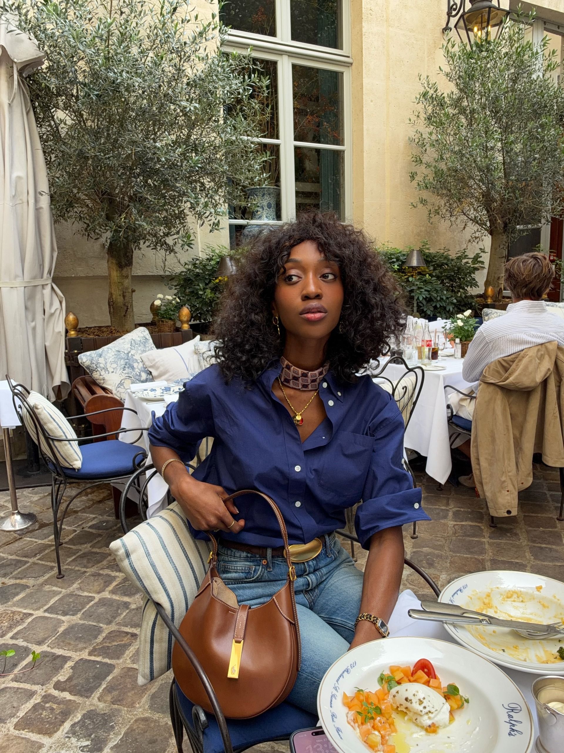 @emmanuellek_ wearing a button-down, belt, jeans, and Ralph Lauren bag