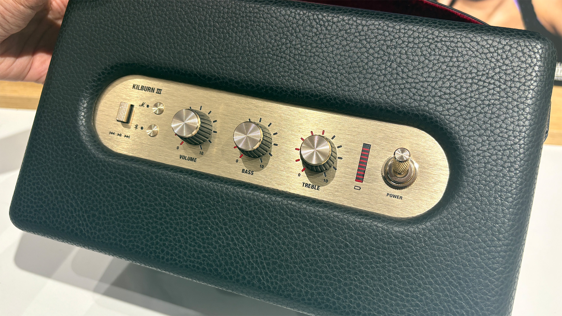 Marshall Kilburn III wireless speaker tilted in hand toward camera to show top panel controls