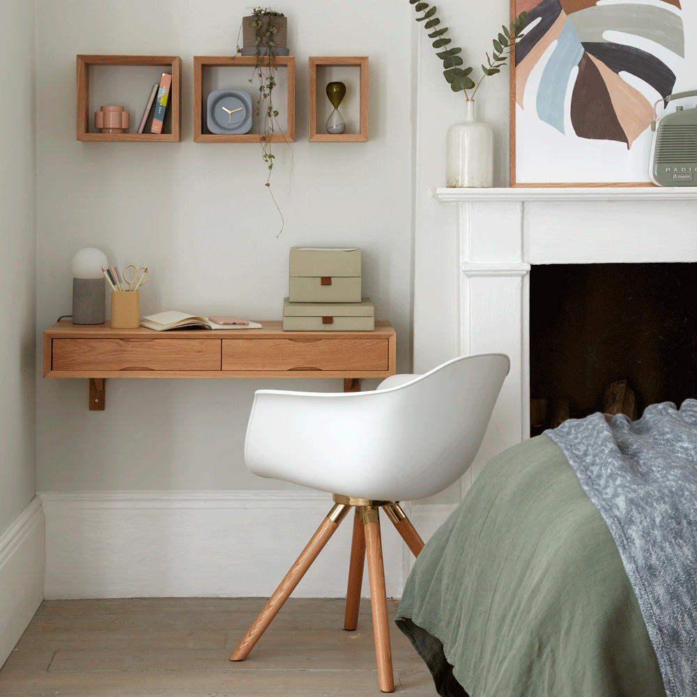 room with white wall and wooden desk with drawer and chair