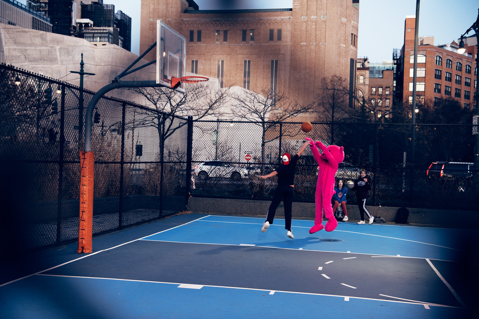 Pink bear shooting basketball hoops in New York