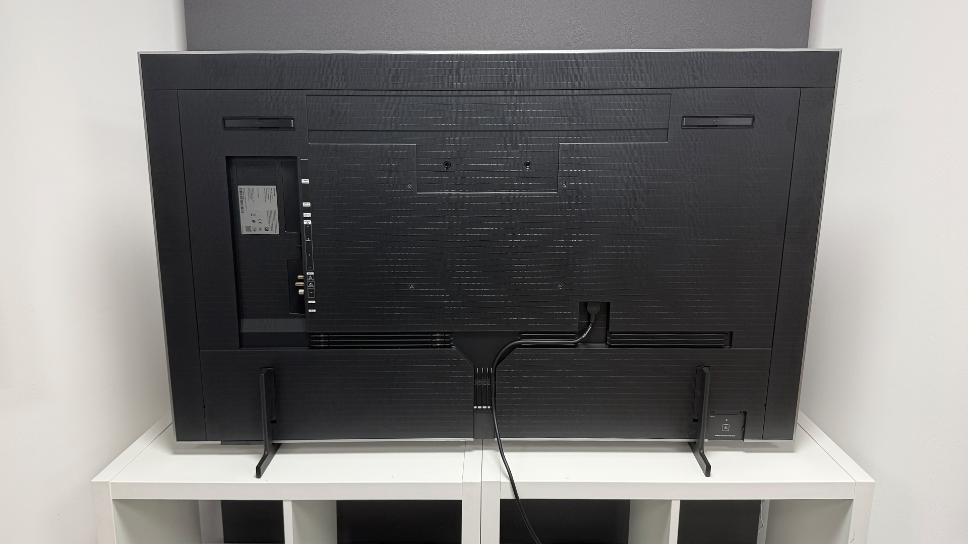 Samsung S99H 55-inch OLED TV on white shelving unit, rear of TV