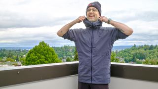 Senior writer Dan Bracaglia wearing the Patagonia Nano-Air Ultralight in grey/blue on the roof of his home in Seattle, Washington with trees and overcast skies in the distance