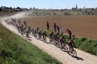 INEOS Grenadiers's riders lead the pack on a cobblestone sector during the 119th edition of the Paris-Roubaix one-day classic cycling race, between Compiegne and Roubaix, northern France, on April 17, 2022. (Photo by Thomas SAMSON / AFP) (Photo by THOMAS SAMSON/AFP via Getty Images)