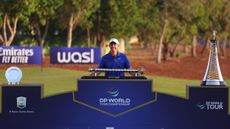 Rory McIlroy in front of the 2024 Race To Dubai and DP World Tour Championship trophies