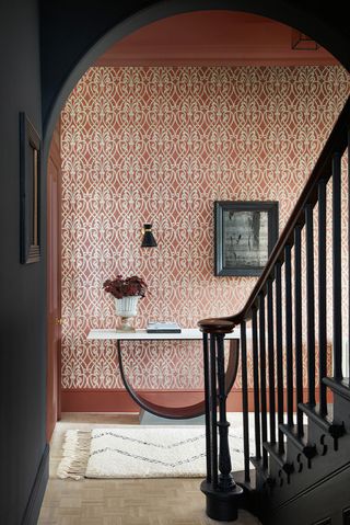 Red and black hallway with black stairs and wallpaper