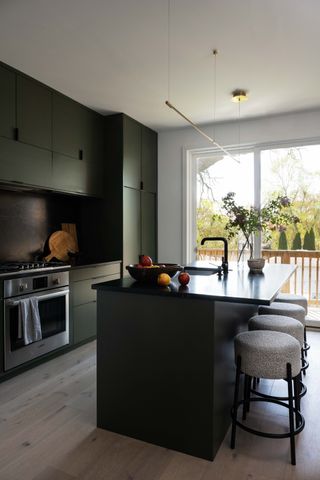 dark green modern kitchen with black countertops
