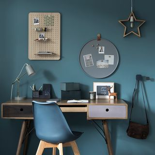 blue office room with wooden table and lamp