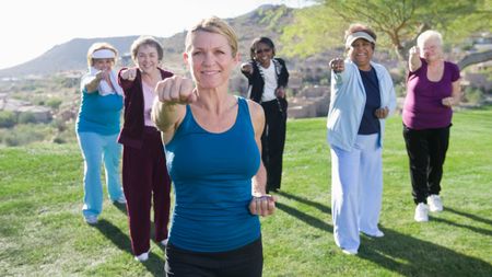 Senior Women taking exercise class outdoors in Arizona