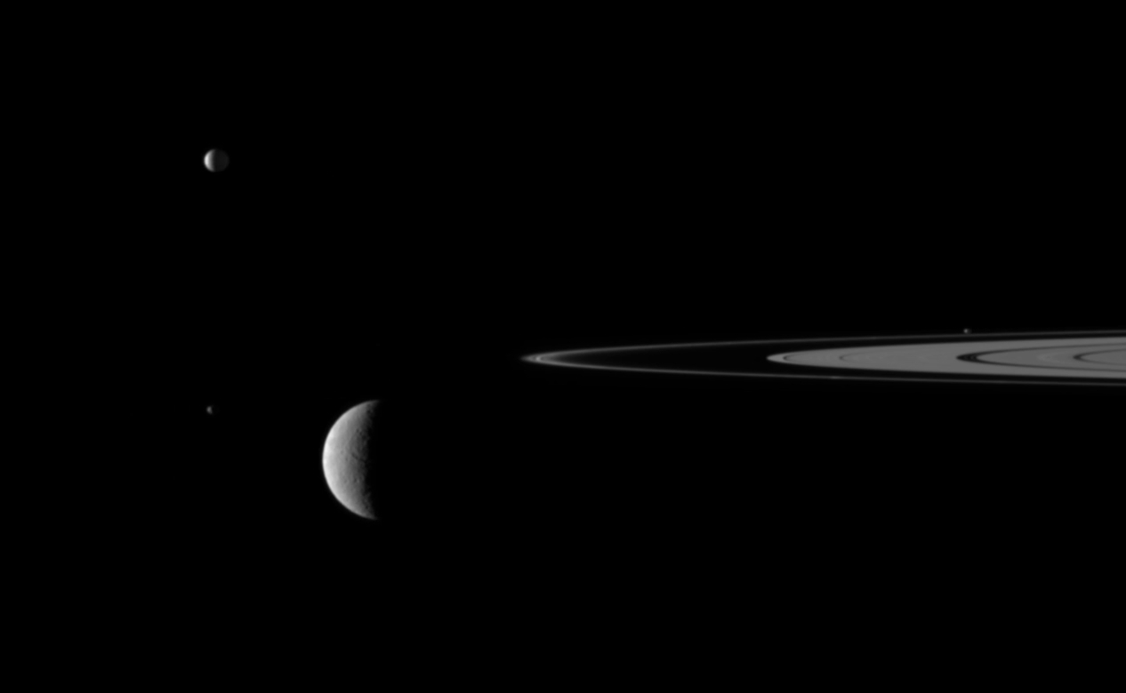 Still from the video &quot;Outer Space&quot; showing Saturn&#039;s rings and four of its moons