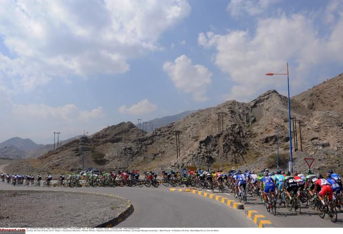 The Tour of Oman peloton navigating through some road furniture during stage 3