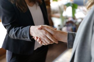 Two business women shaking hands