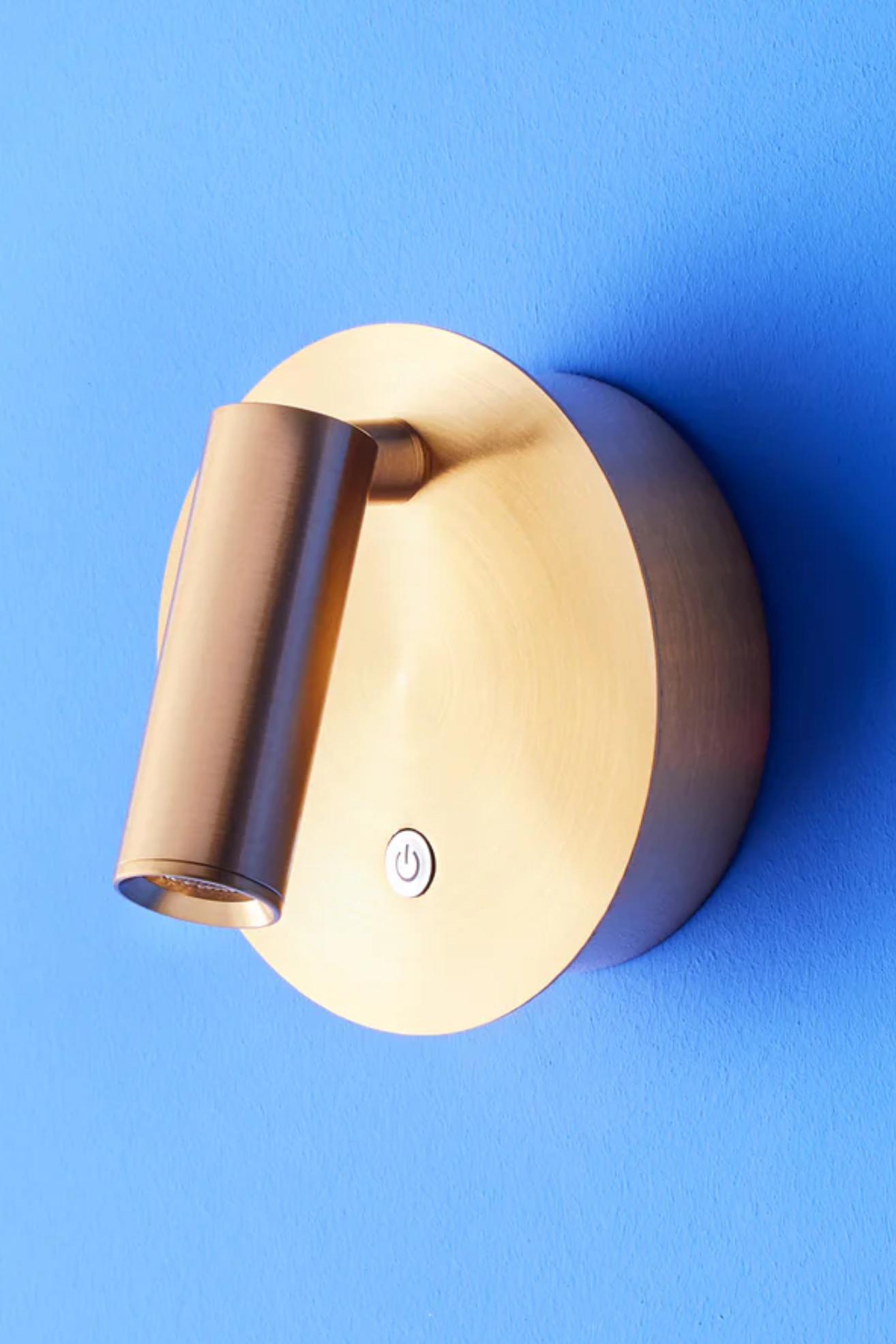 A brassy wall sconce reading light