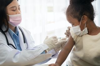 A healthcare worker vaccinates a child.