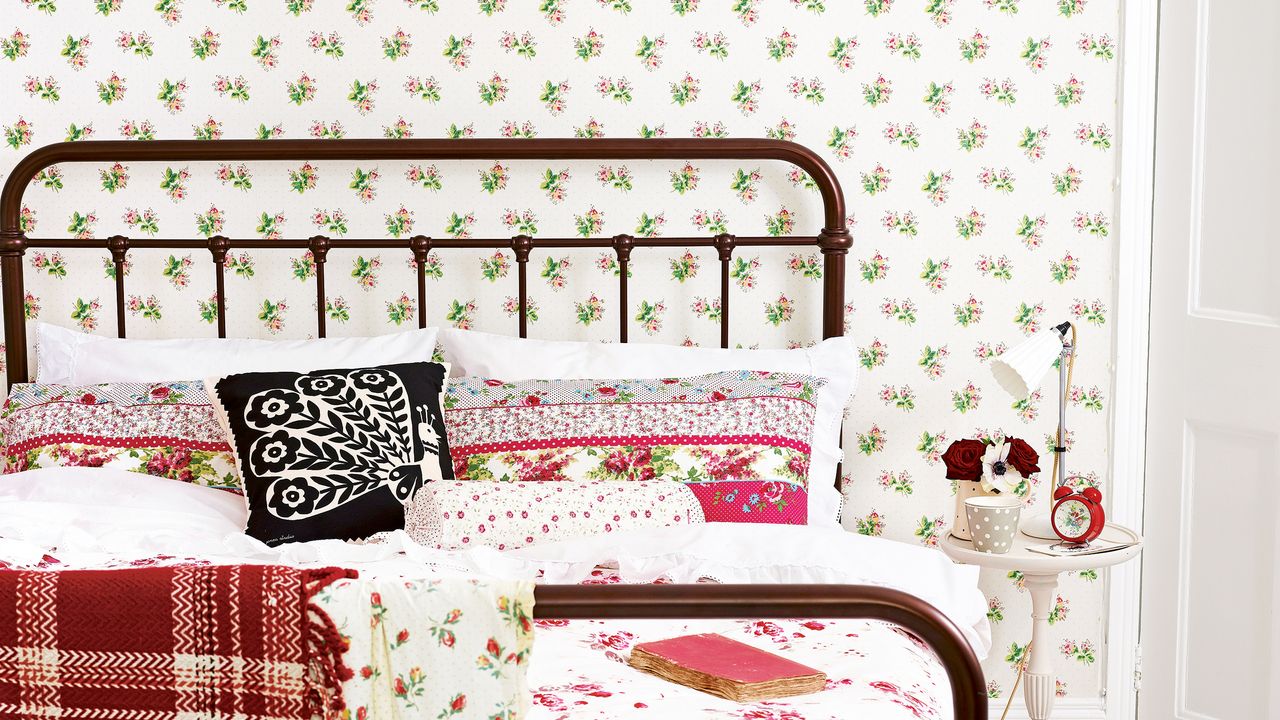 Bedroom with wrought iron bed and floral wallpaper