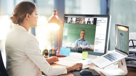 woman in office video chatting on a Mac