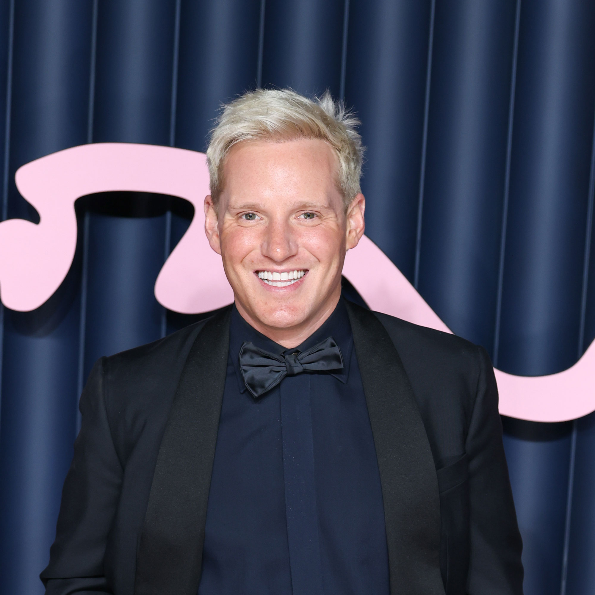 Jamie Laing in a blue suit in front of a blue background