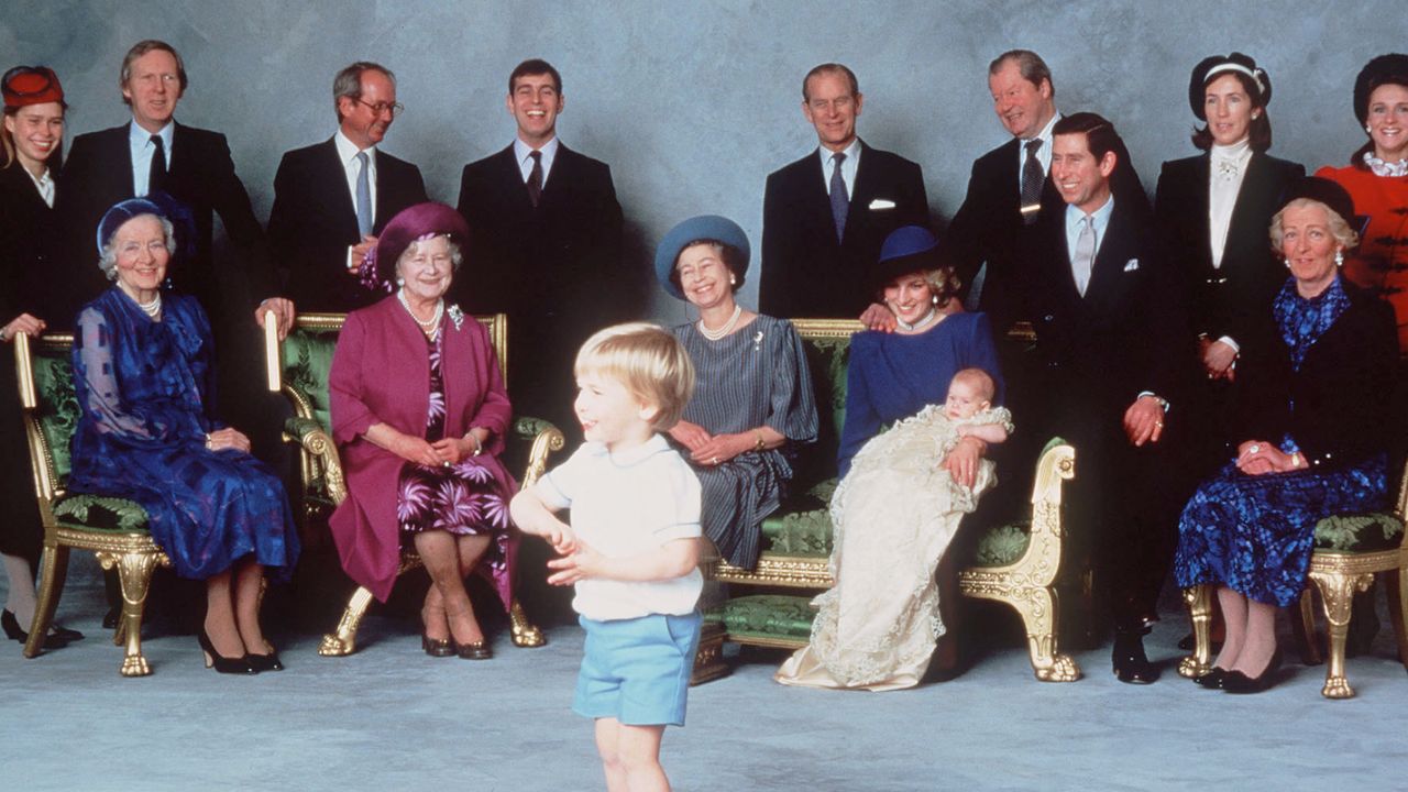 Young Prince William standing in front of a large group of royals posing for a picture at Prince Harry&#039;s christening