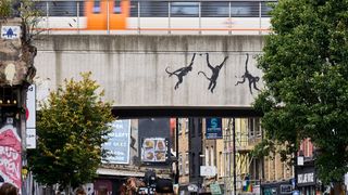 An artwork featuring three monkeys by Banksy, adorns a bridge over Brick Lane on August 07, 2024 of London, England