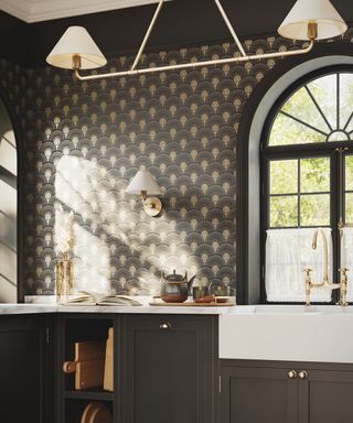 gray kitchen with dark gray cabinets and art deco style wallpaper, white countertops and sink, retro white pendant lights