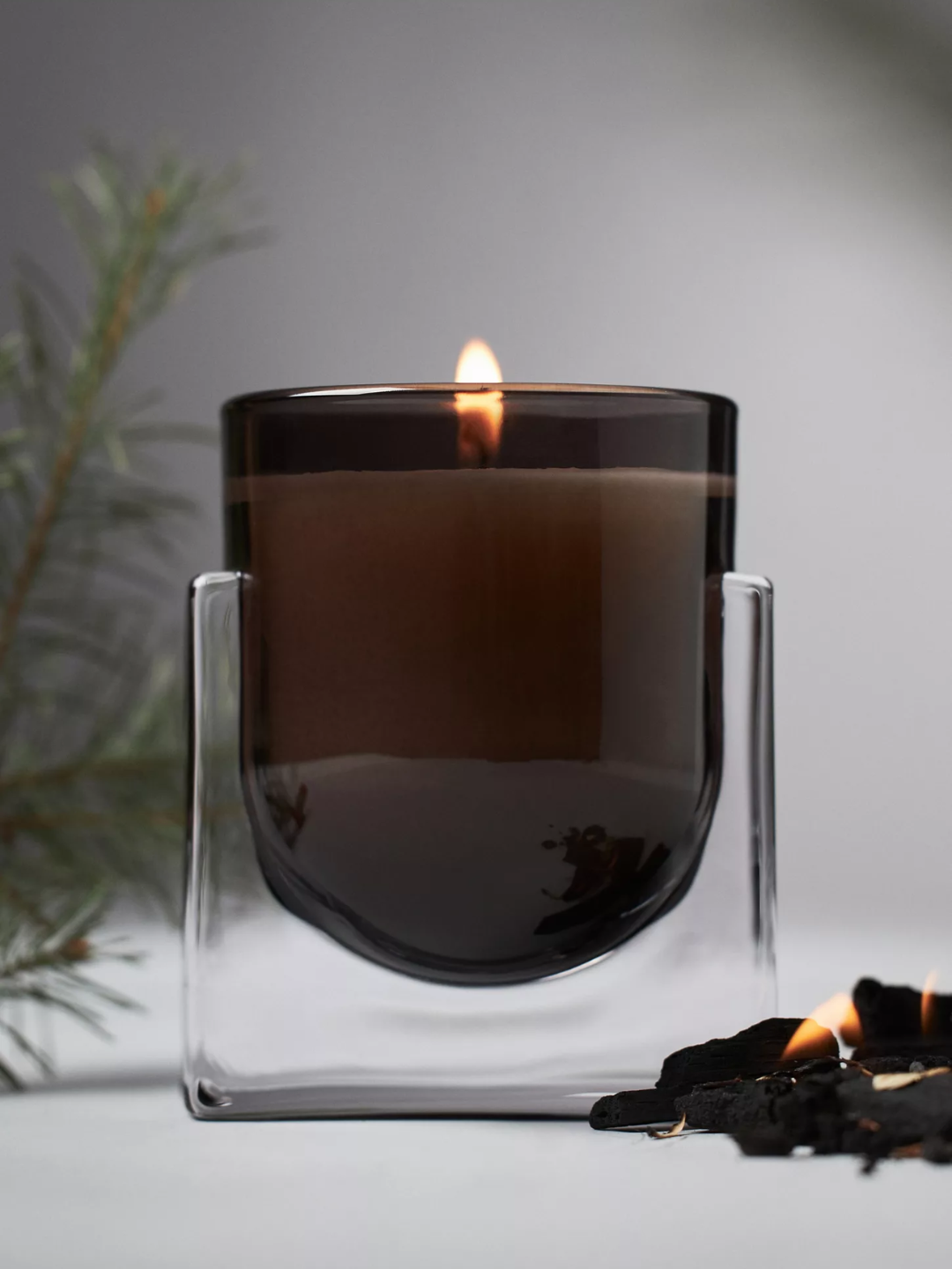 A black glass spice evergreen and embers candle by Found Notes from Anthropologie