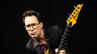 Paul Gilbert holding an Ibanez guitar