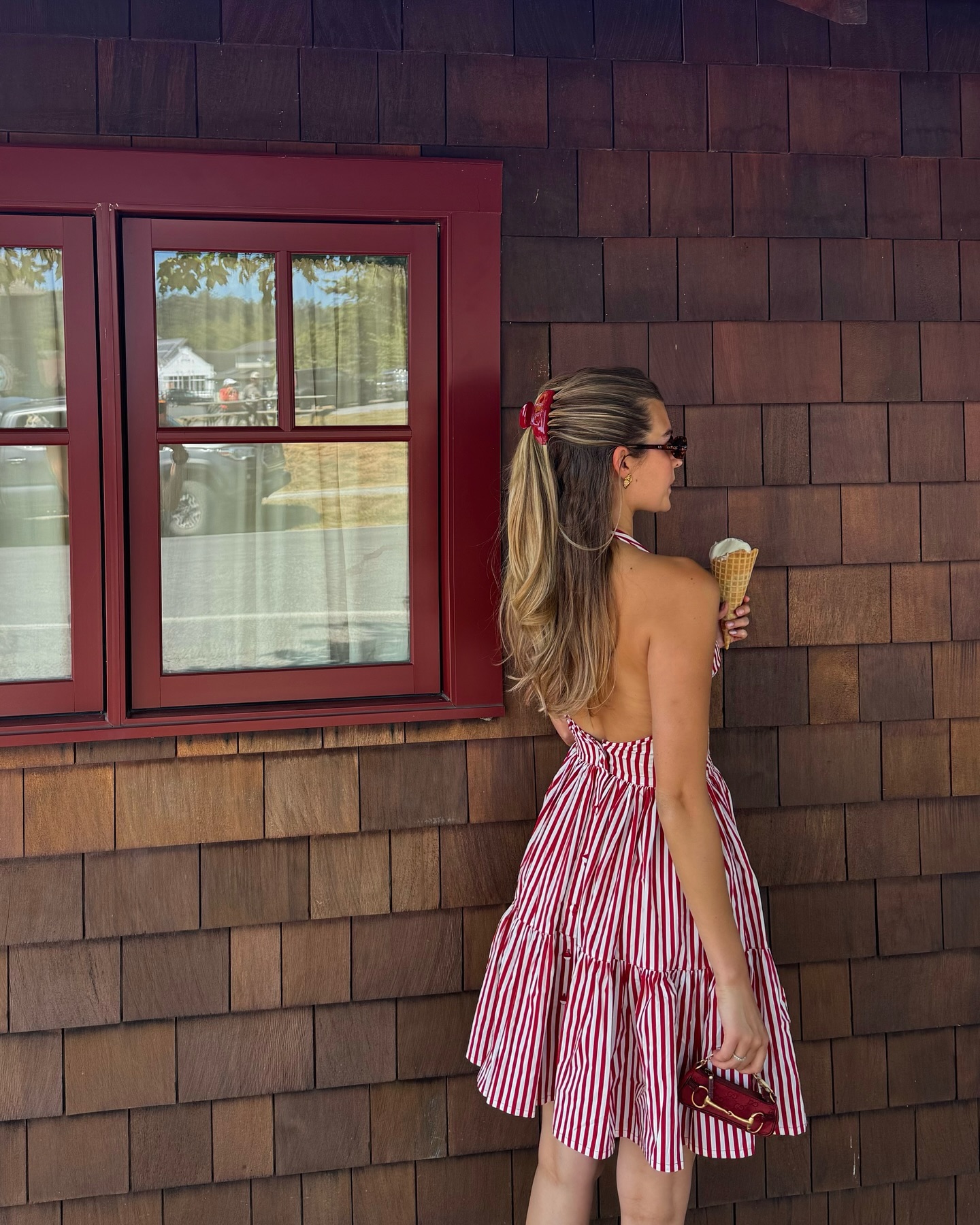 @styledsara wears a red and white striped halterneck mini dress whilst eating an ice-cream cone