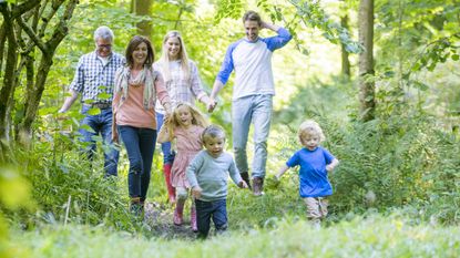 A multigeneration family walks in the woods in spring.