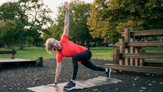 Woman performs thoracic rotation in park