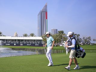 Joaquin Niemann walking on the golf course with caddie Gary Matthews