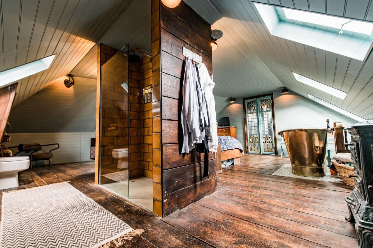 The back of the bedroom has a shower behind the bed and toilet which is connected to the bedroom