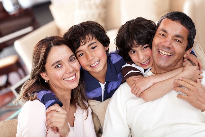 A happy family with two parents and two chlidren.