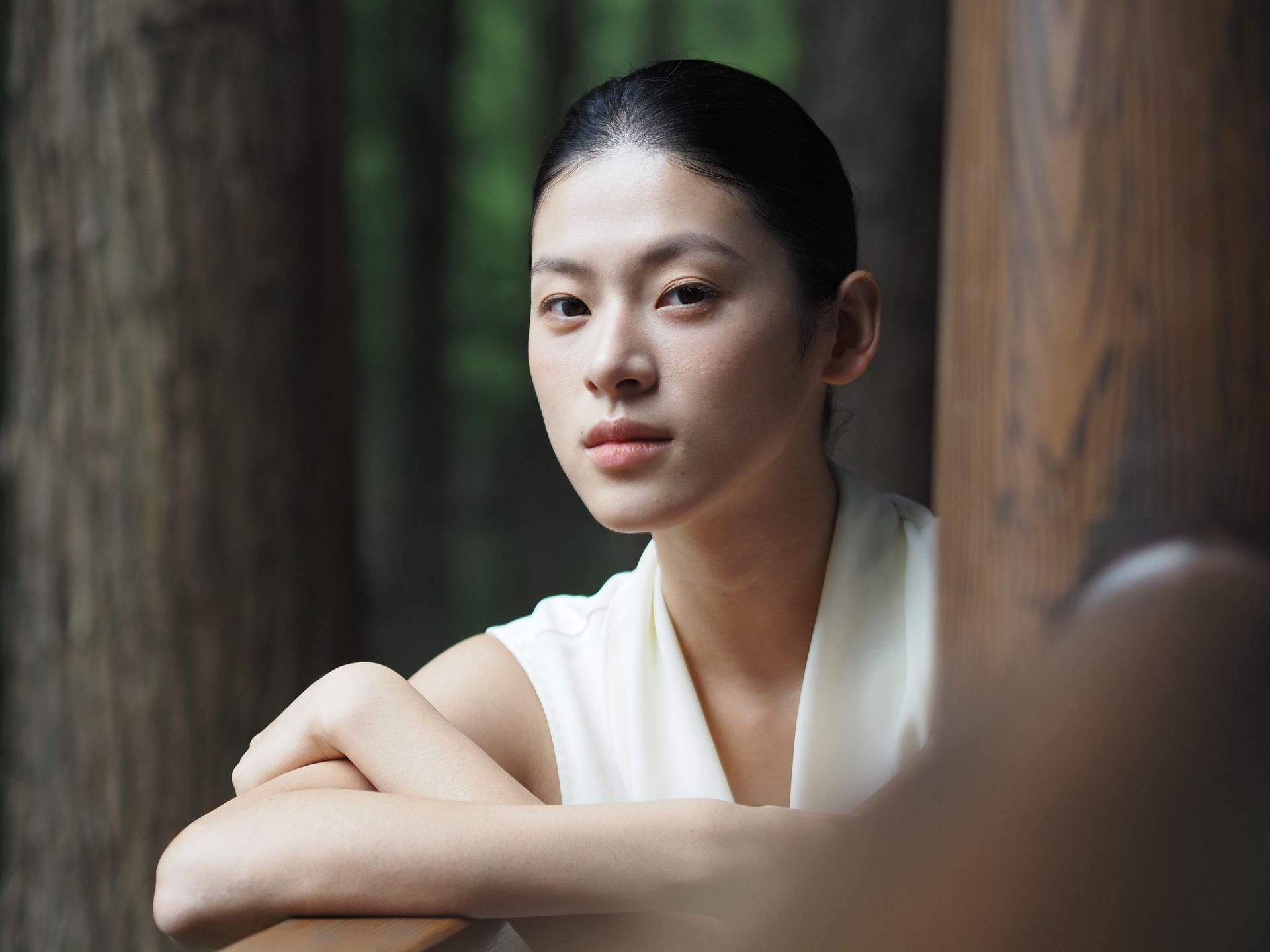  Female model in white dress, set among wooden pillars