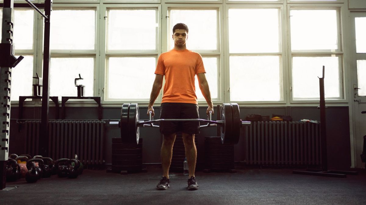 Man performs trap-bar deadlift exercise