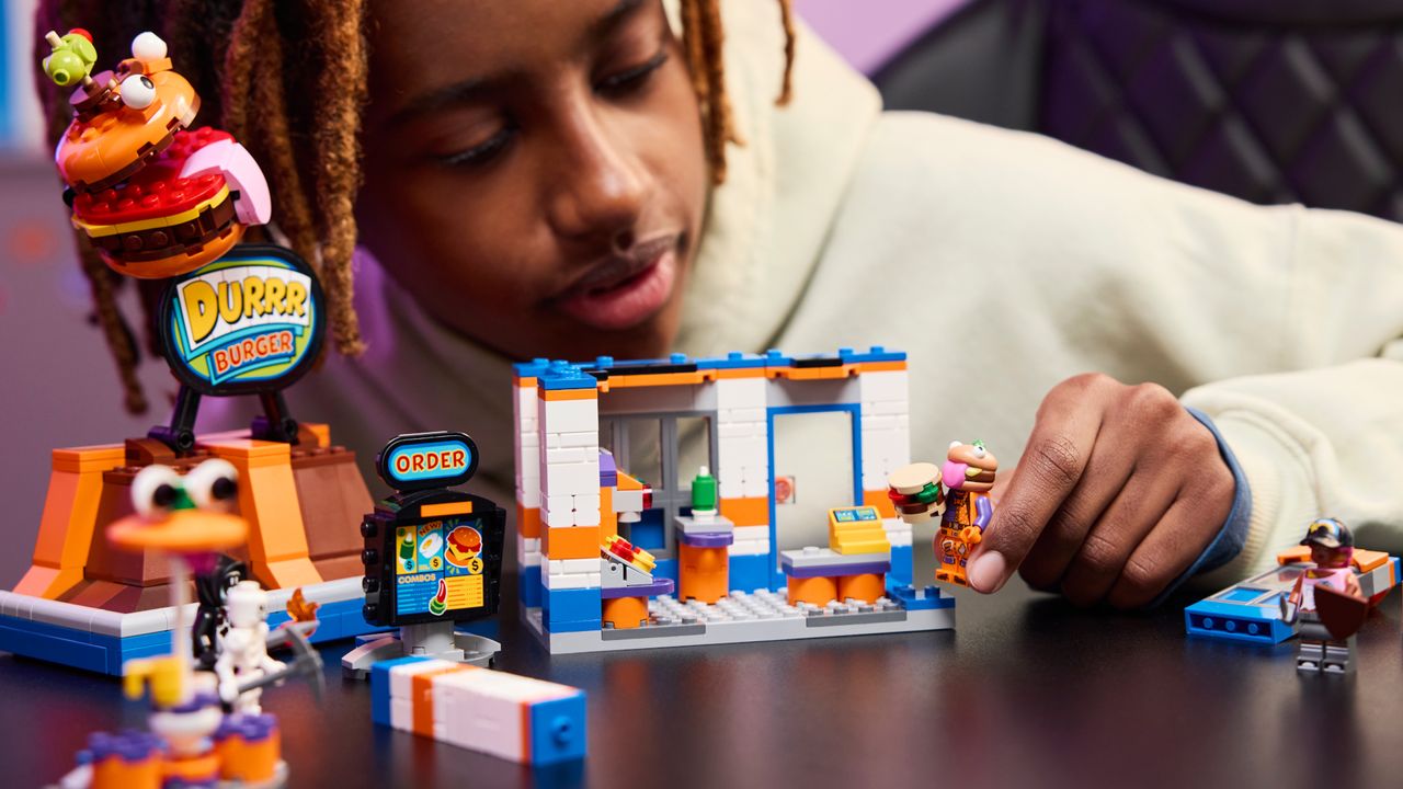 A child playing with the Lego Durrr Burger Restaurant and minifigures