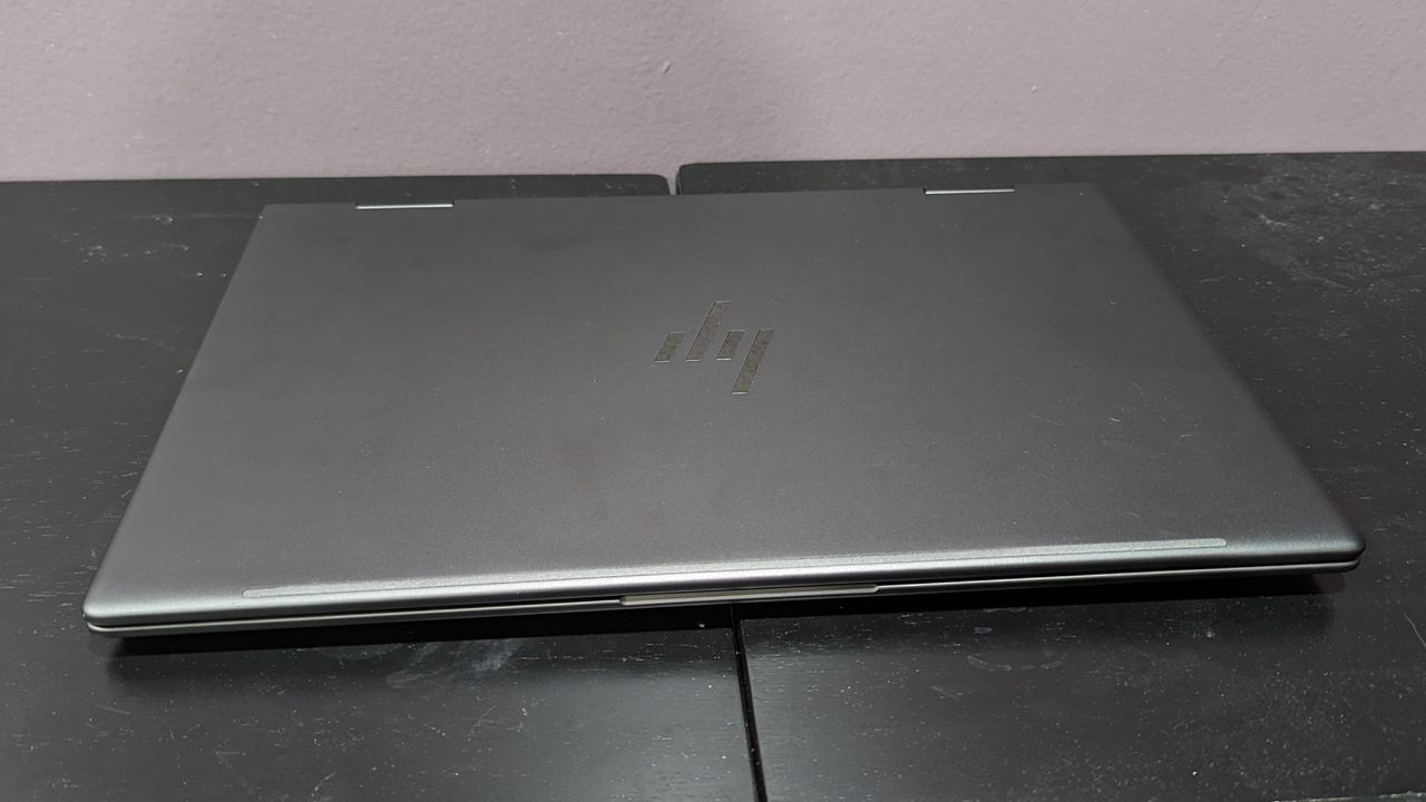 HP Envy x360 closed on a black desktop.