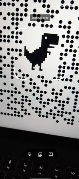 Android has updated its QR code scanner with a new bottom viewfinder UI with a flash icon, assistance icon, and the pre-existing "scan from photo" option.