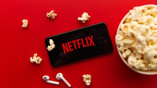 Netflix-logo på mobiltelefon og popcorn i en bolle