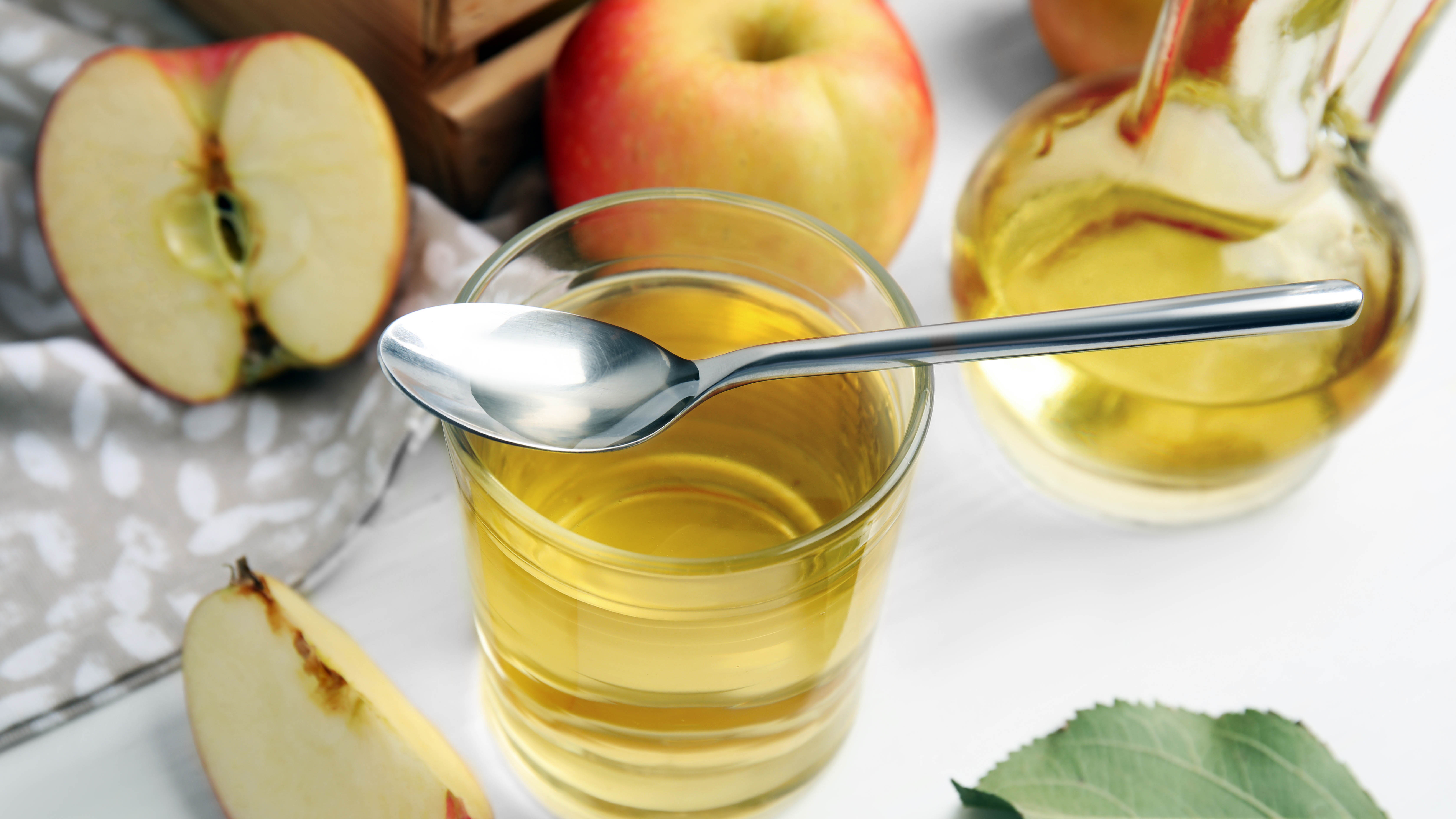Glass of apple cider vinegar with apples