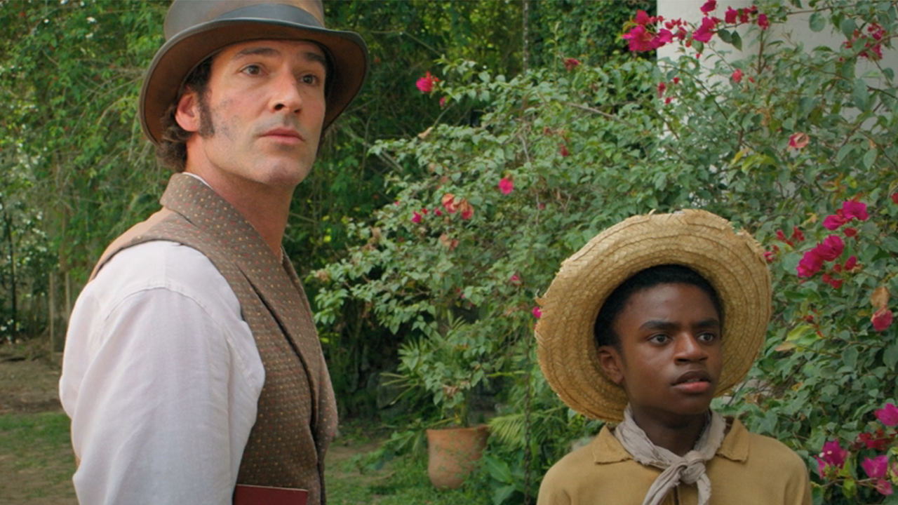 Tom Ellis in a vest and top hat standing next to Eddie Karanja in a straw hat in Washington Black