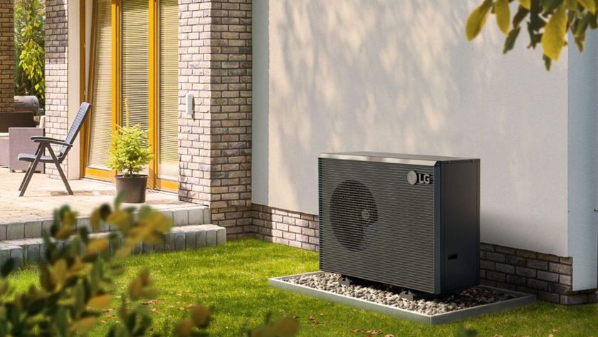 A black outdoor heat pump positioned against a wall 