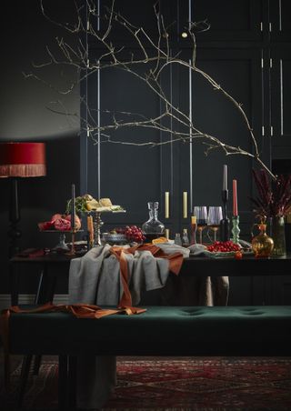 An autumnal themed dining table tablescape with candles and red details
