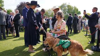 Duchess of Gloucester speaks with Isabelle Atkins and Rumba, her assistance dog